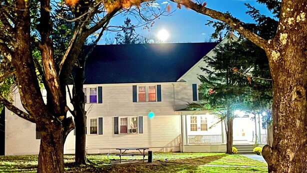 A house with a visible front yard, a bench, and a visible street lamp. - Grand Lake Hotel (Lebanon)