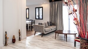 A modern living room with a sofa, dining table, and chairs. There are decorative vases and a plant on the floor. - LUXURY HOUSE VILLA DEVOTO (Buenos Aires)
