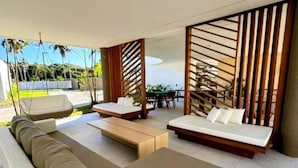 Una zona exterior moderna amb seients, un sofà, una taula de fusta i una taula de dinar.