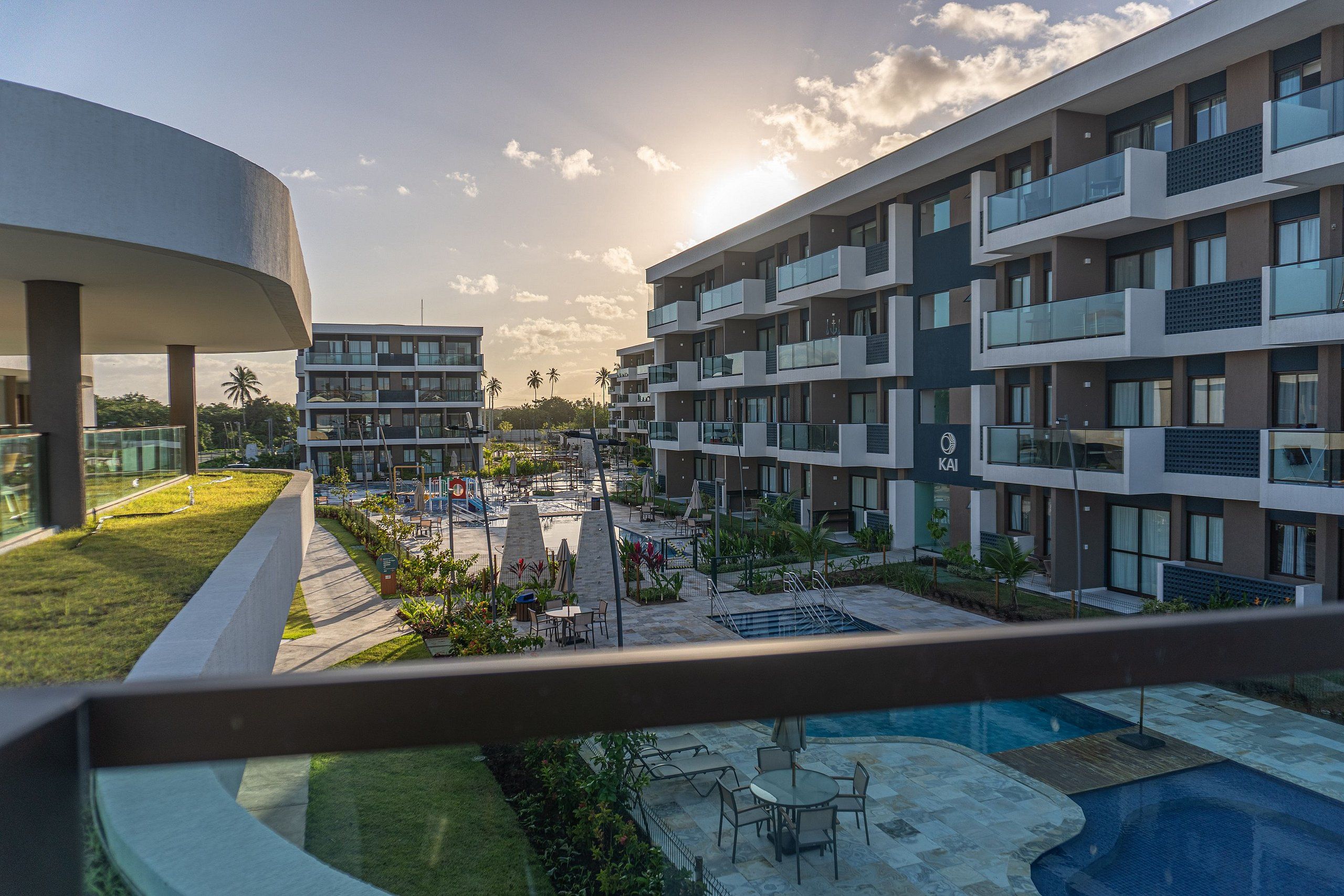 Un hôtel moderne doté de nombreux balcons, d’un espace piscine et d’un jardin aménagé.