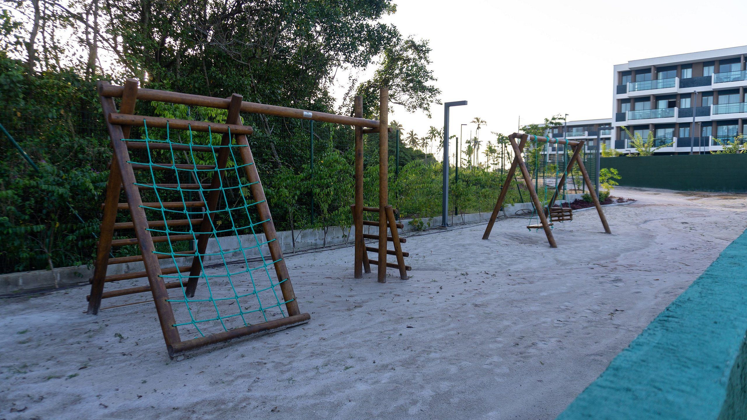 Un parque infantil con columpios y una estructura para escalar.