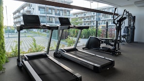A gym with treadmills, a stationary bike, and weight machines. - Makia Beach Experience Porto de Galinhas (Ipojuca)
