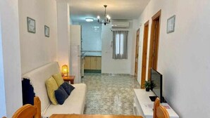 A compact living space with a sofa, a dining table, and a TV.