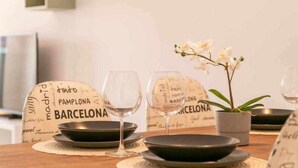 A dining table set with black plates, wine glasses, and a potted orchid. - Modern two bedroom apartment in Nerja center (Nerja)