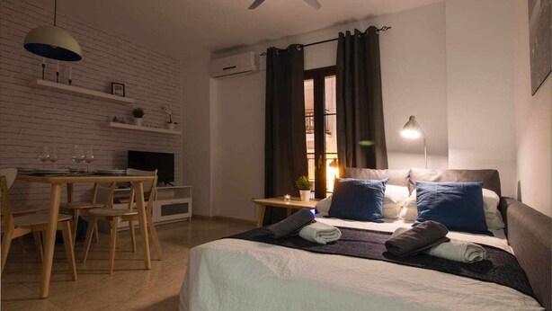 A bedroom with a bed, bedside table, and a desk with chairs. - P3. Moderno Apartamento en el Centro de Nerja (Nerja)