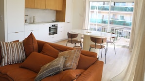 A modern kitchen with white cabinets and a dining area with a round table and chairs.