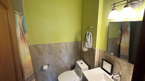 Une salle de bain avec des toilettes, un lavabo et un miroir.