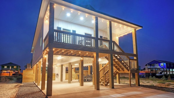 A two-story house with a balcony, a staircase, and a covered outdoor area.