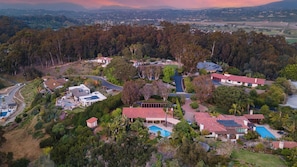An aerial view of a residential area with houses, a swimming pool, and a road.