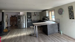 Una cucina moderna con elettrodomestici in acciaio inossidabile, un'isola centrale e un'area pranzo.