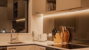 Una cocina moderna con horno empotrado, tostadora, fregadero y bloque para cuchillos.