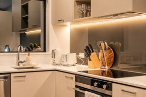 A modern kitchen with a built-in stove, a coffee maker, a toaster, and a knife block. - Fitzgerald | 3BR + Parking | Sleeps 7 (Christchurch)