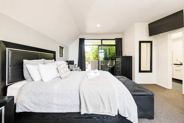 Un dormitorio moderno con una cama grande, un escritorio y un armario.