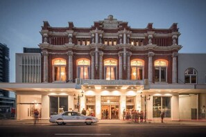 A historic theater building with a classic facade, large arched windows, and a marquee reading "Isaac Theatre Royal."