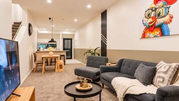 Una sala de estar moderna con un sofá gris, una mesa de centro y un televisor de pantalla plana.