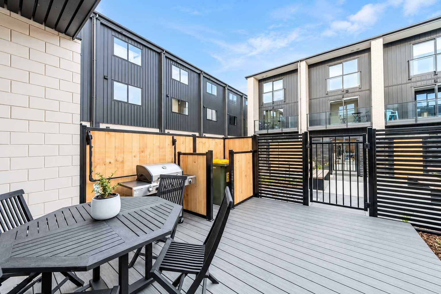 A patio area with a grill, table, and chairs.