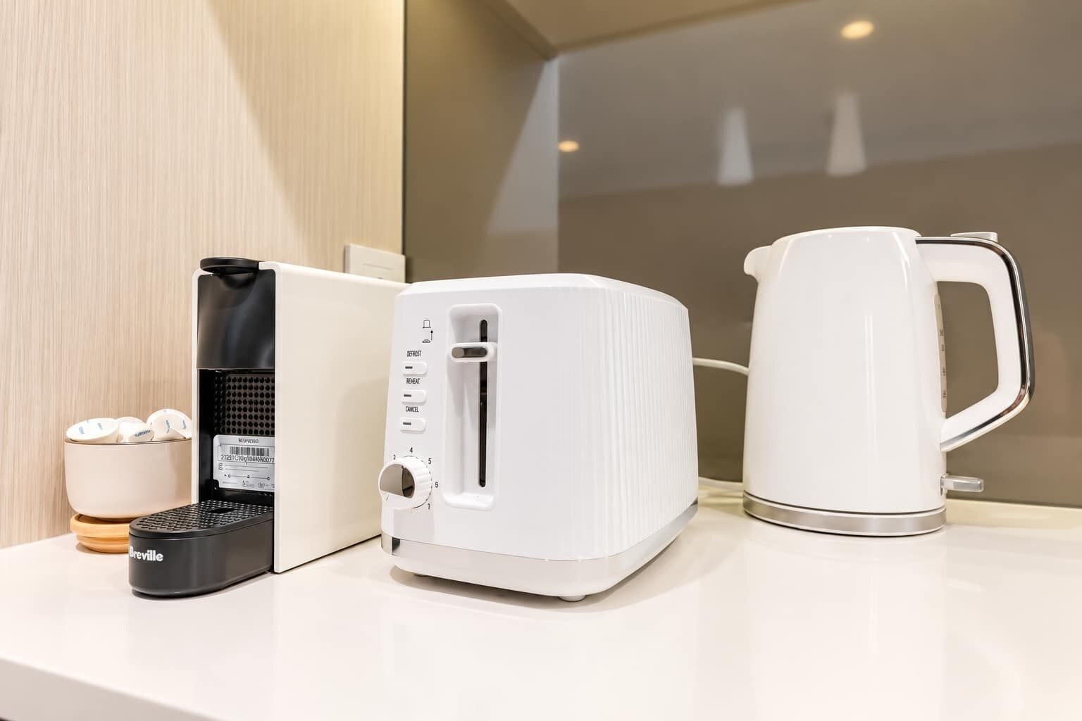 Una encimera de cocina con una cafetera, un tostador y un aparato Breville.