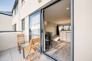 A modern apartment with a balcony, a dining area, and a kitchen.