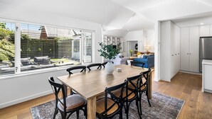 A modern kitchen with white cabinets, a built-in oven, and a stainless steel refrigerator. - KaleidoNook | 3BR + Parking + Private Yard (Christchurch)