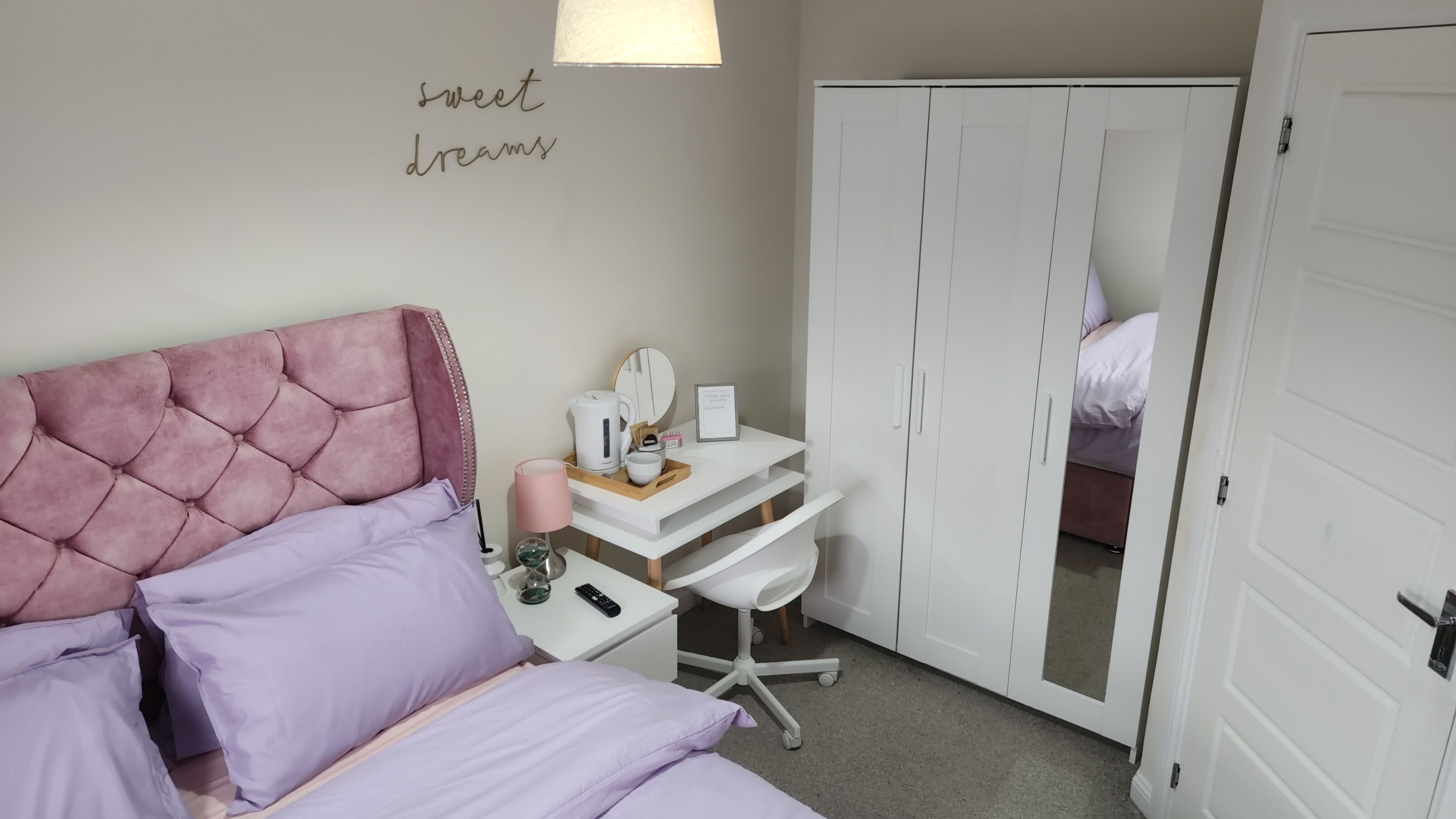 Un dormitorio con cama, escritorio y armario.