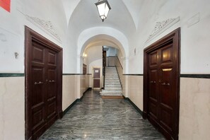A hallway with marble flooring, wooden doors, and an arched ceiling. - Cavour - Large and comfortable apartment for 6 close to the Coloseum (Roma)