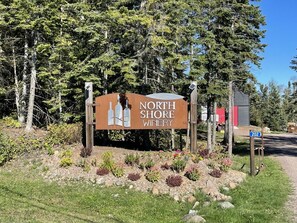 A sign for North Shore Winery with a number 202 signpost nearby.