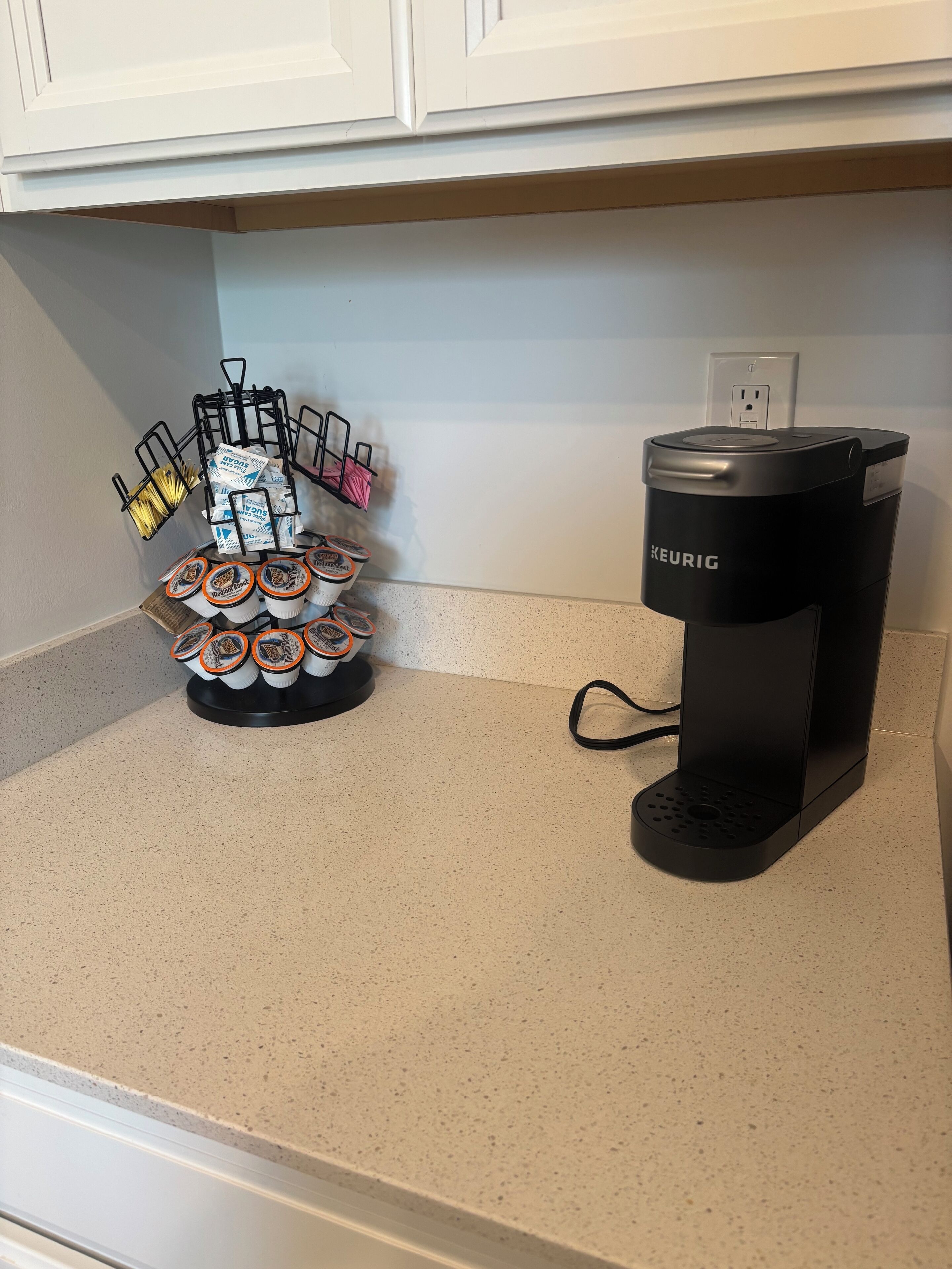 Een keukentablet met een Keurig koffiezetapparaat en een houder voor koffiekapsules.