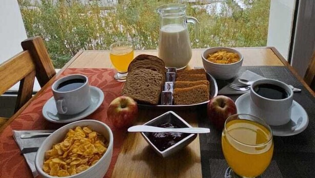 Une table de petit-déjeuner avec vue sur les montagnes, comprenant une montagne, des bâtiments et une route.
