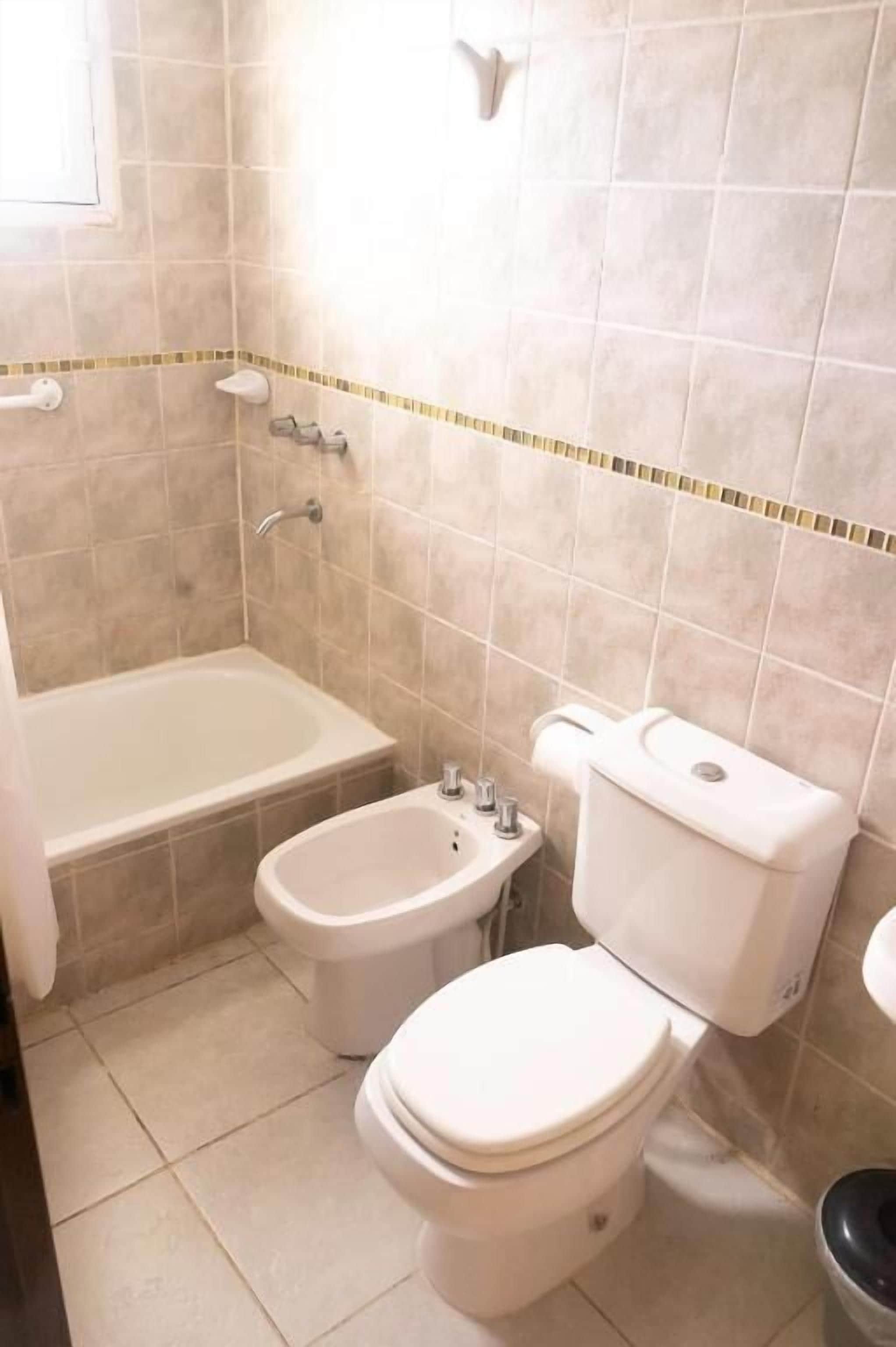 Ein Badezimmer mit einer Badewanne, zwei Toiletten und einem Bidet.