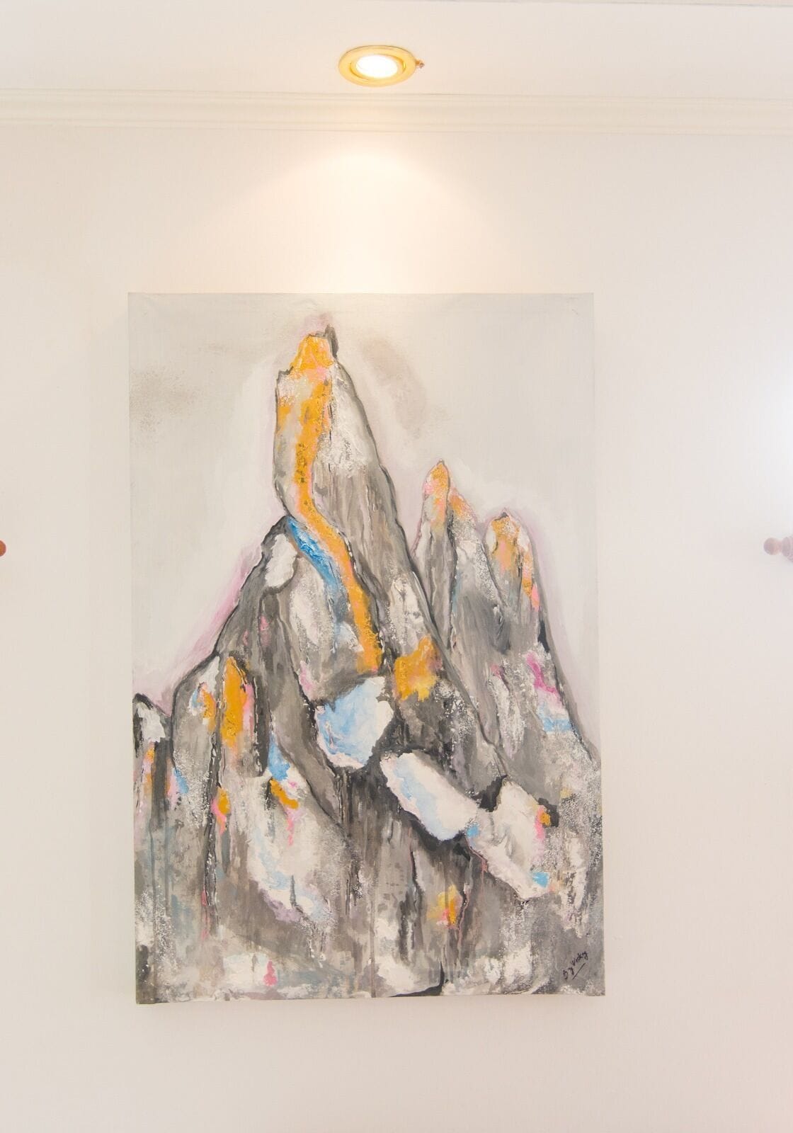 Una pintura de una cadena montañosa en una pared blanca.