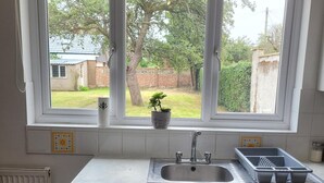 A kitchen with a window, a sink, and a potted plant. - 1 Bedroom - Sleeps 3 - Free Parking (Luton)