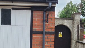A brick wall with a black door and a CCTV warning sign. - 1 Bedroom - Sleeps 3 - Free Parking (Luton)
