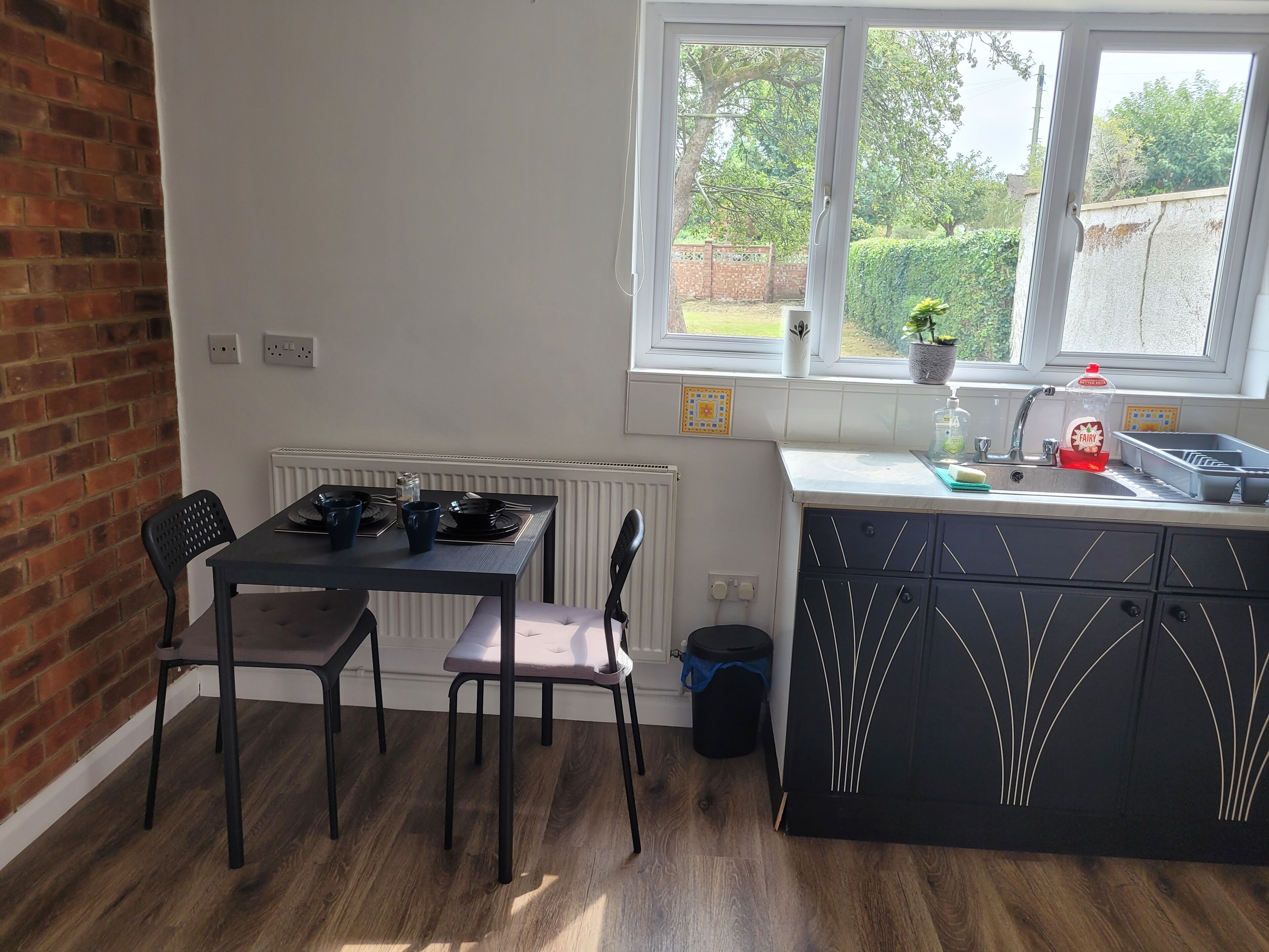 Une cuisine équipée d’une table à manger, de chaises, d’une fenêtre et d’un évier.