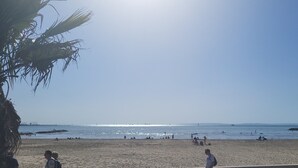 Ein Strand mit Menschen, Palmen und blauem Himmel.