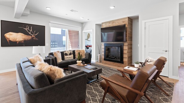 A modern living room with a fireplace, a sofa set, and a dining area. - Chic Bozeman Getaway - Minutes from Downtown! (Bozeman)