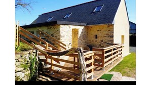 Ein rustikales Steinhaus mit einer Holztreppe, die zu einer Terrasse führt.