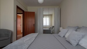 Une chambre à coucher avec un grand lit, une chaise et une armoire.