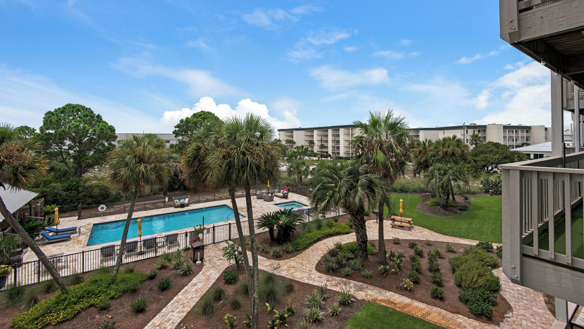 A pool area with a clear view of the surrounding landscape, including a building in the background.