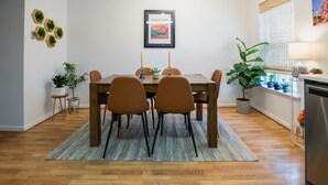 Un coin repas avec une table en bois, quatre chaises et un tapis bleu.