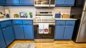 Une cuisine moderne avec des meubles bleus, des appareils en acier inoxydable et un four Samsung.
