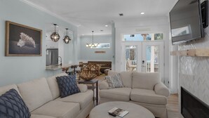 A modern living room with a sectional sofa, a dining area with a bench, and a kitchen in the background. - 3 Minutes to Beach - Community Pool - Classic Seagrove Home (Santa Rosa Beach)