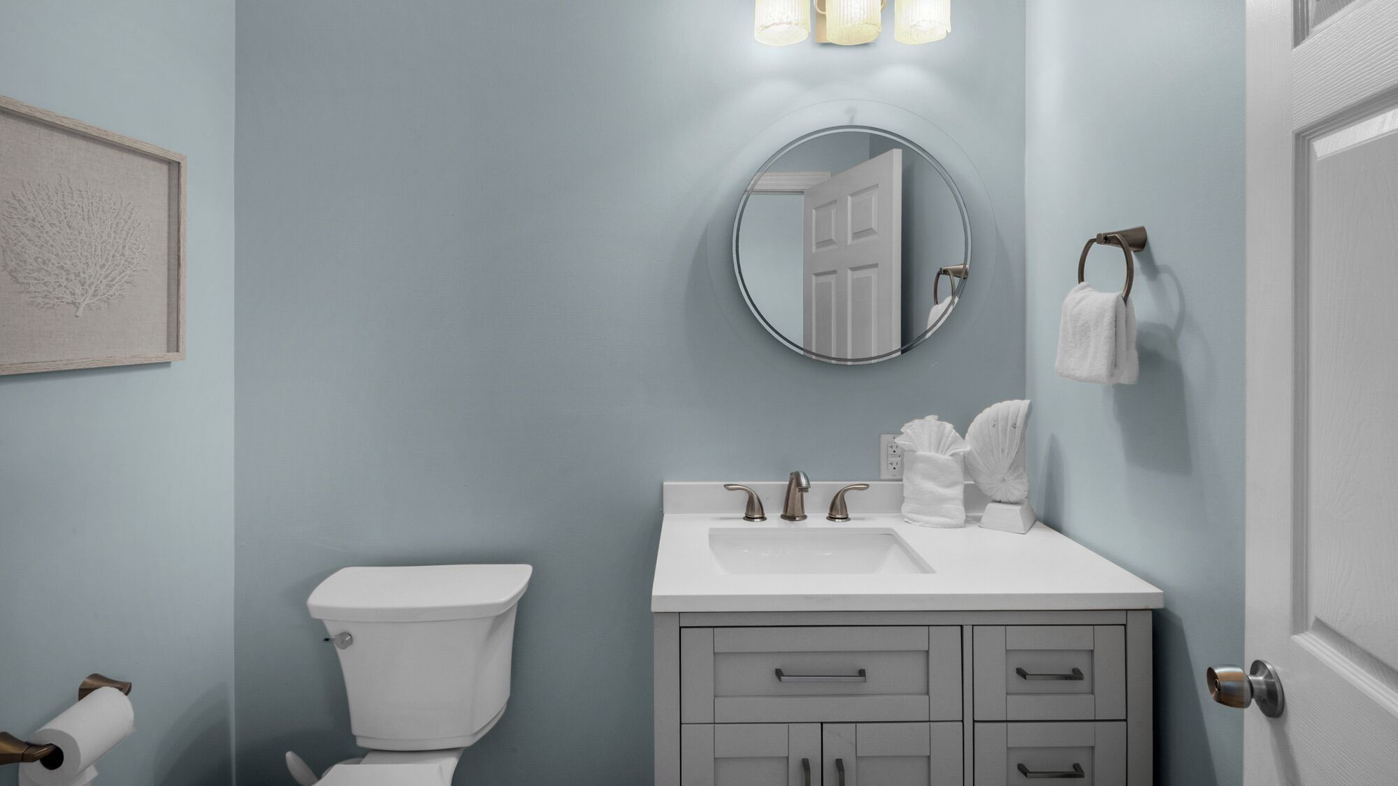 A bathroom with a toilet, sink, and vanity.