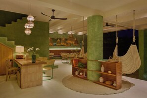 A modern interior with a wooden bar, green walls, hanging lights, a hammock, and a ceiling fan. - Punta Nayaá - Adults Only (Santa Maria Colotepec)