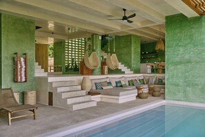 A modern interior with a pool, a staircase, and a seating area with cushions. - Punta Nayaá - Adults Only (Santa Maria Colotepec)