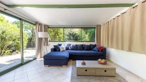 Un salón moderno con un sofá modular, una mesa de centro y vistas a zonas verdes.