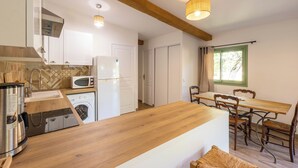 A modern kitchen with a wooden island, a washing machine, a microwave, and a refrigerator. - 06BV2 : Nice cottage with pool (Grasse)