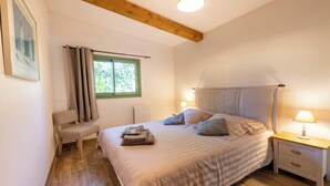 A bedroom with a bed, bedside tables, a bench, a window with curtains, and a ceiling light. - 06BV2 : Nice cottage with pool (Grasse)