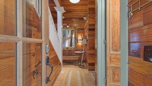 A wooden hallway with a bench, a wall-mounted lamp, and a door with a keyhole. - 3br/3.ba With Dock, Deck/balcony and Fireplace (Santa Rosa Beach)