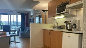 A modern kitchen with wooden cabinets, a microwave, a coffee maker, and a dishwasher.