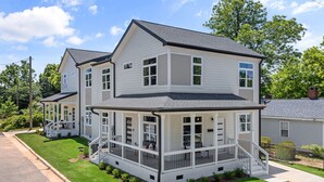 A two-story house with a covered porch and a small front yard. - Brand New 4bd - Modern - Prime Location - Spacious (Raleigh)